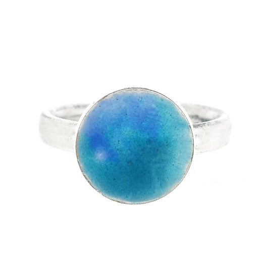 A silver ring band with a round silver top coloured with turquoise and turquoise blue enamel.