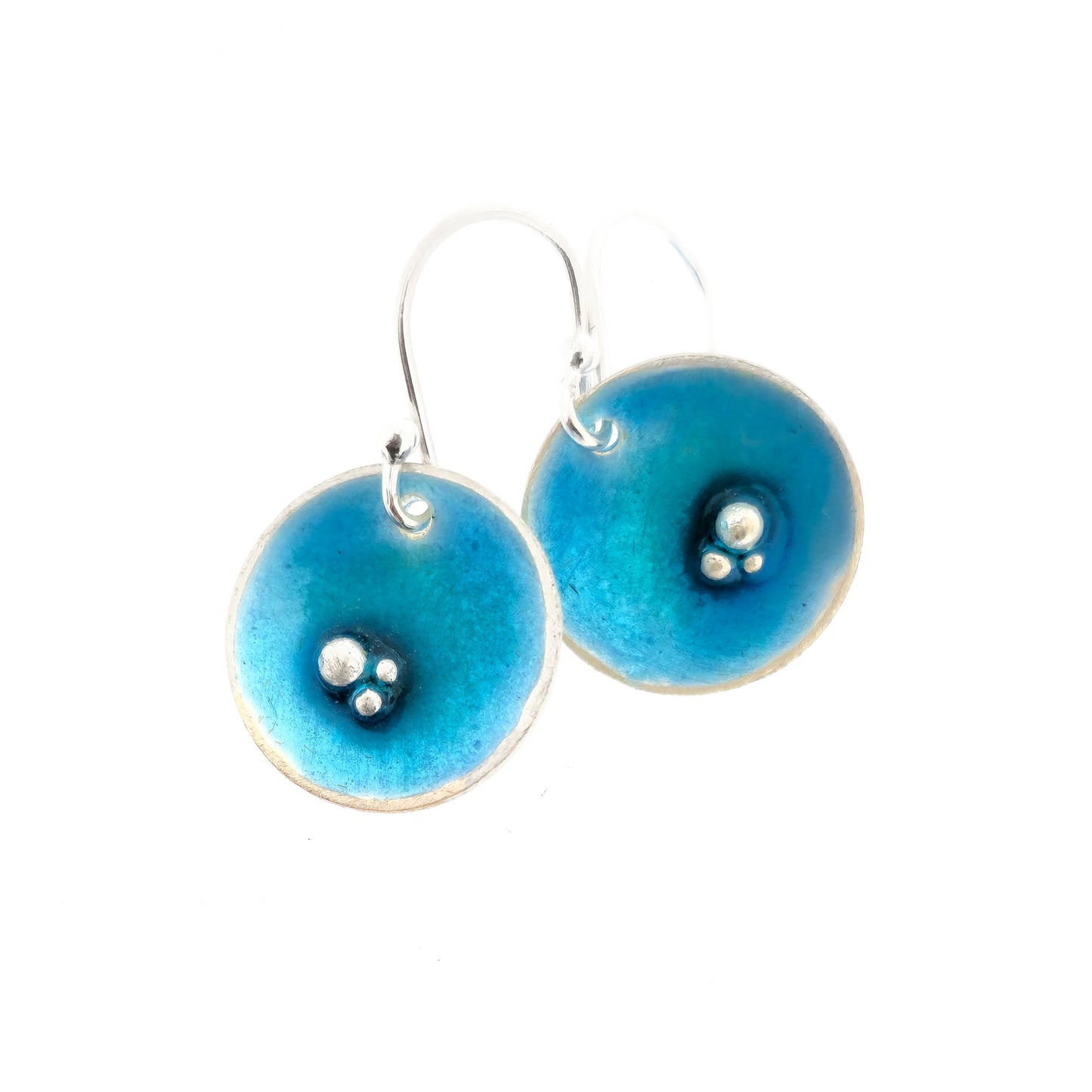 Round silver drop earrings. Each earring has 3 silver balls off-centre and a turquoise blue enamel. Suspended from silver ear hooks.