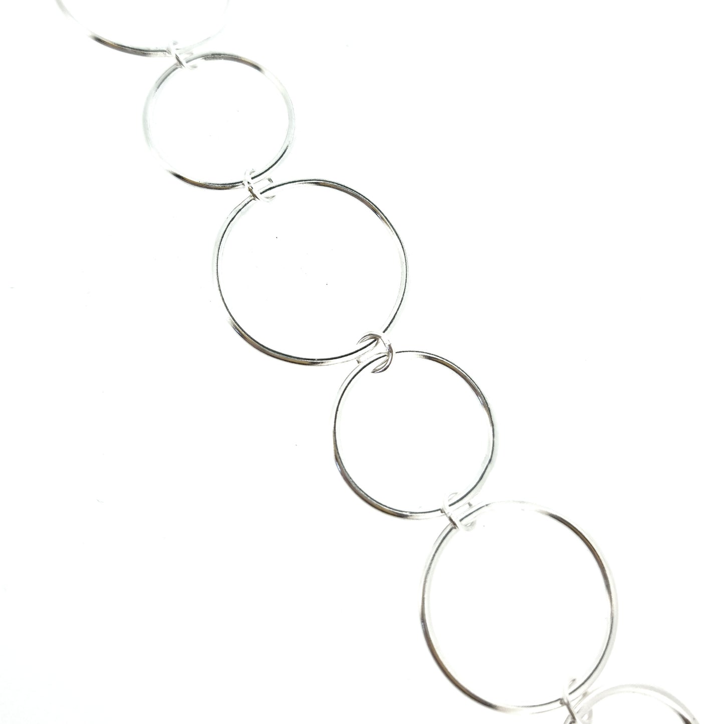 Silver chain link bracelet with circle links of different sizes.