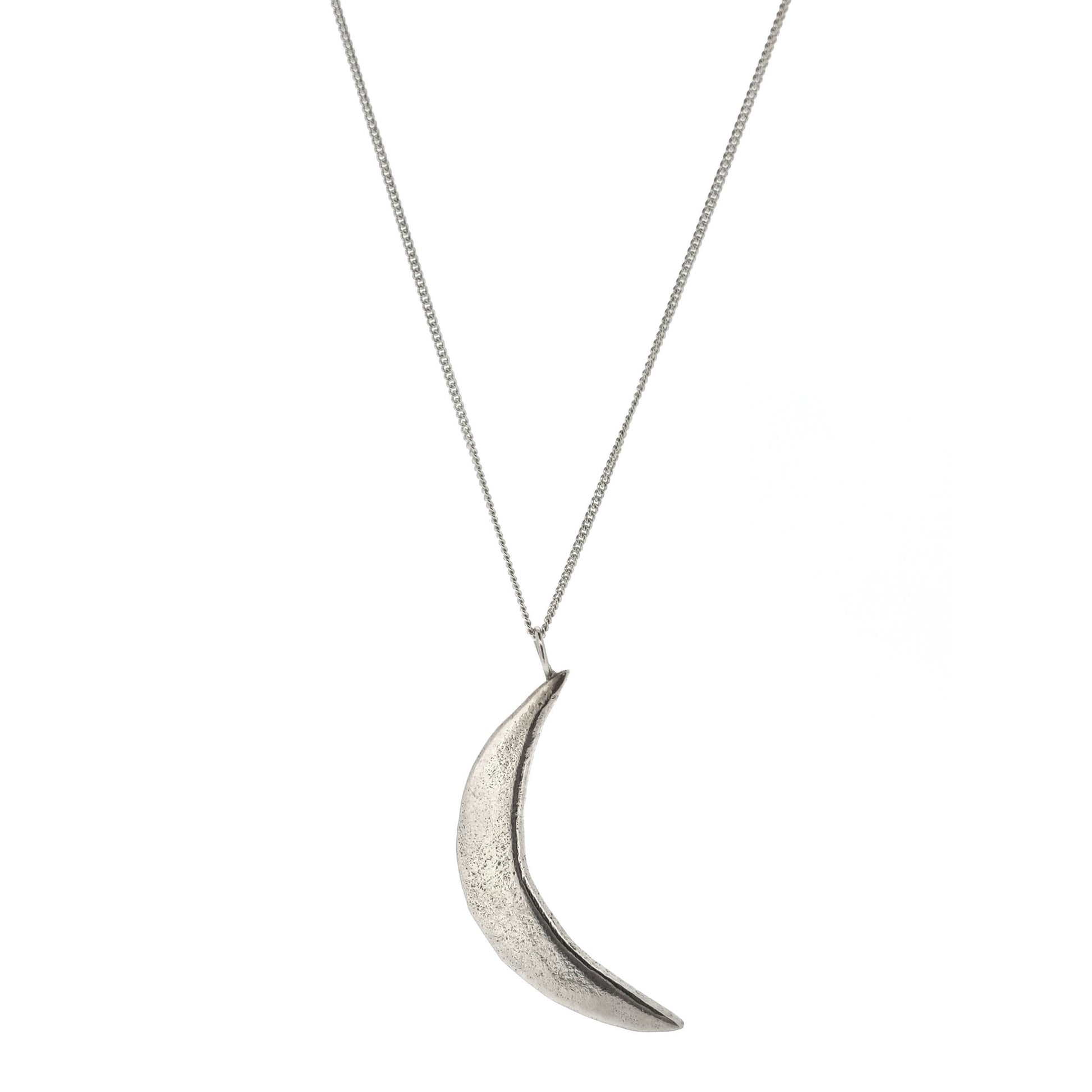 An organic silver crescent moon pendant on a silver chain.