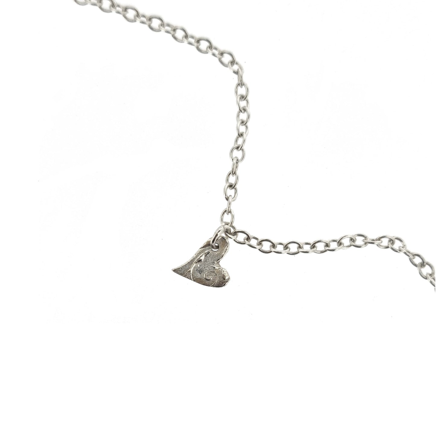 Sterling silver adjustable chain bracelet with small asymmetrical heart charm.