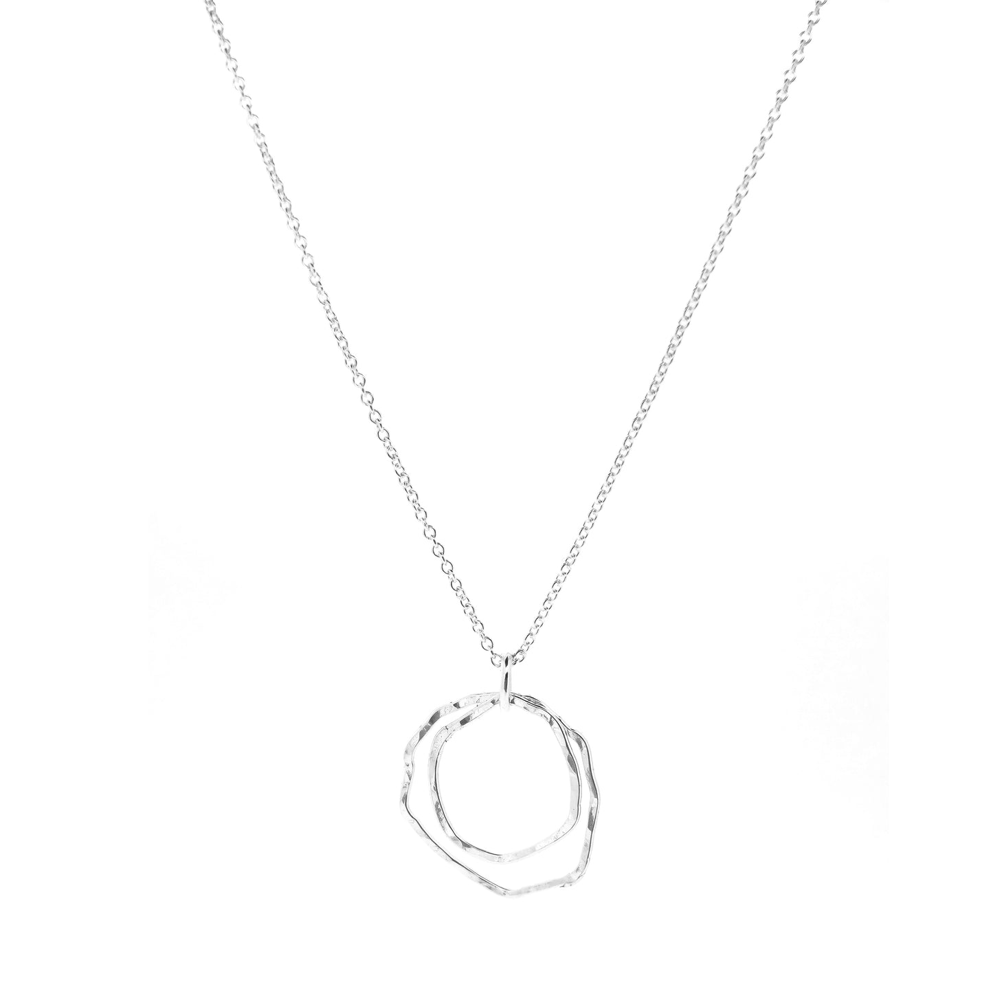 A silver pendant consisting of two organic rustic style open circles of different sizes suspended from a silver chain.