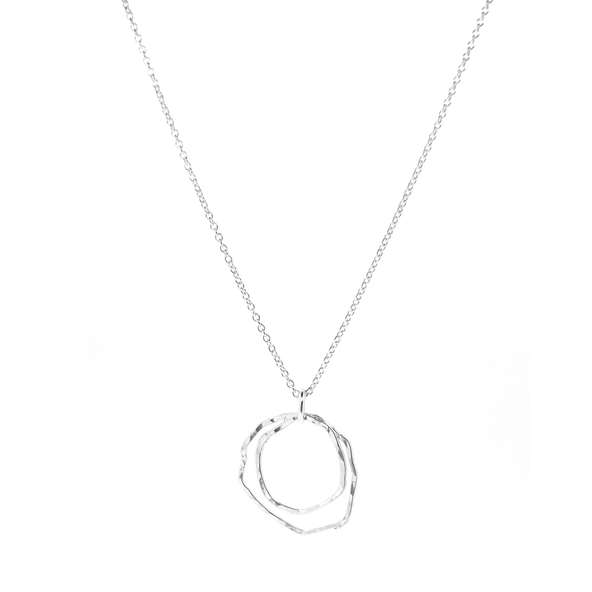 A silver pendant consisting of two organic rustic style open circles of different sizes suspended from a silver chain.