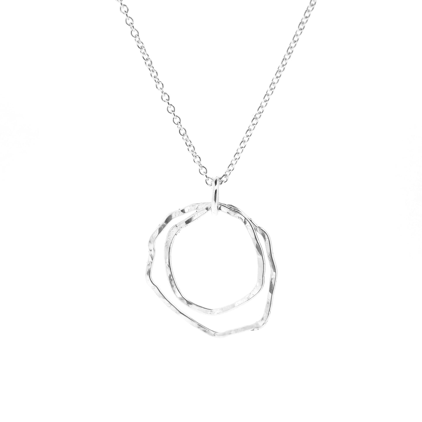 A silver pendant consisting of two organic rustic style open circles of different sizes suspended from a silver chain.