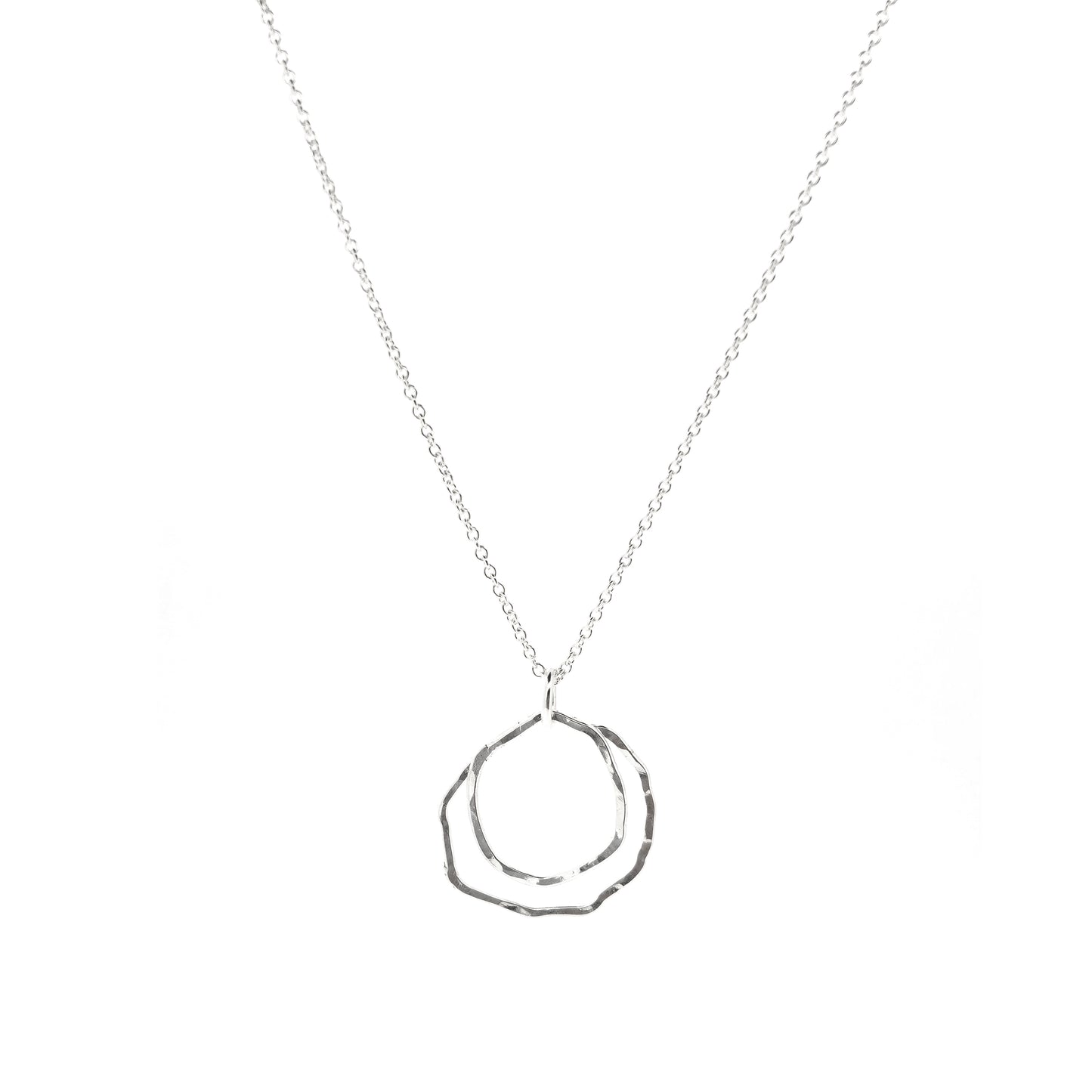 A silver pendant consisting of two organic rustic style open circles of different sizes suspended from a silver chain.