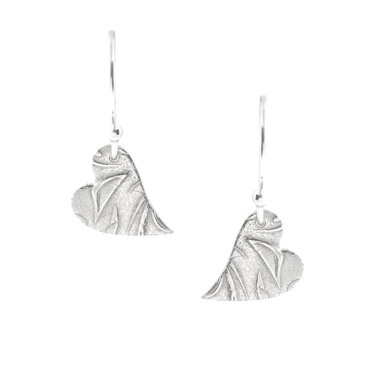 Silver heart drop earrings featuring an asymmetrical heart with a leaf and vine pattern suspended from silver ear hooks.