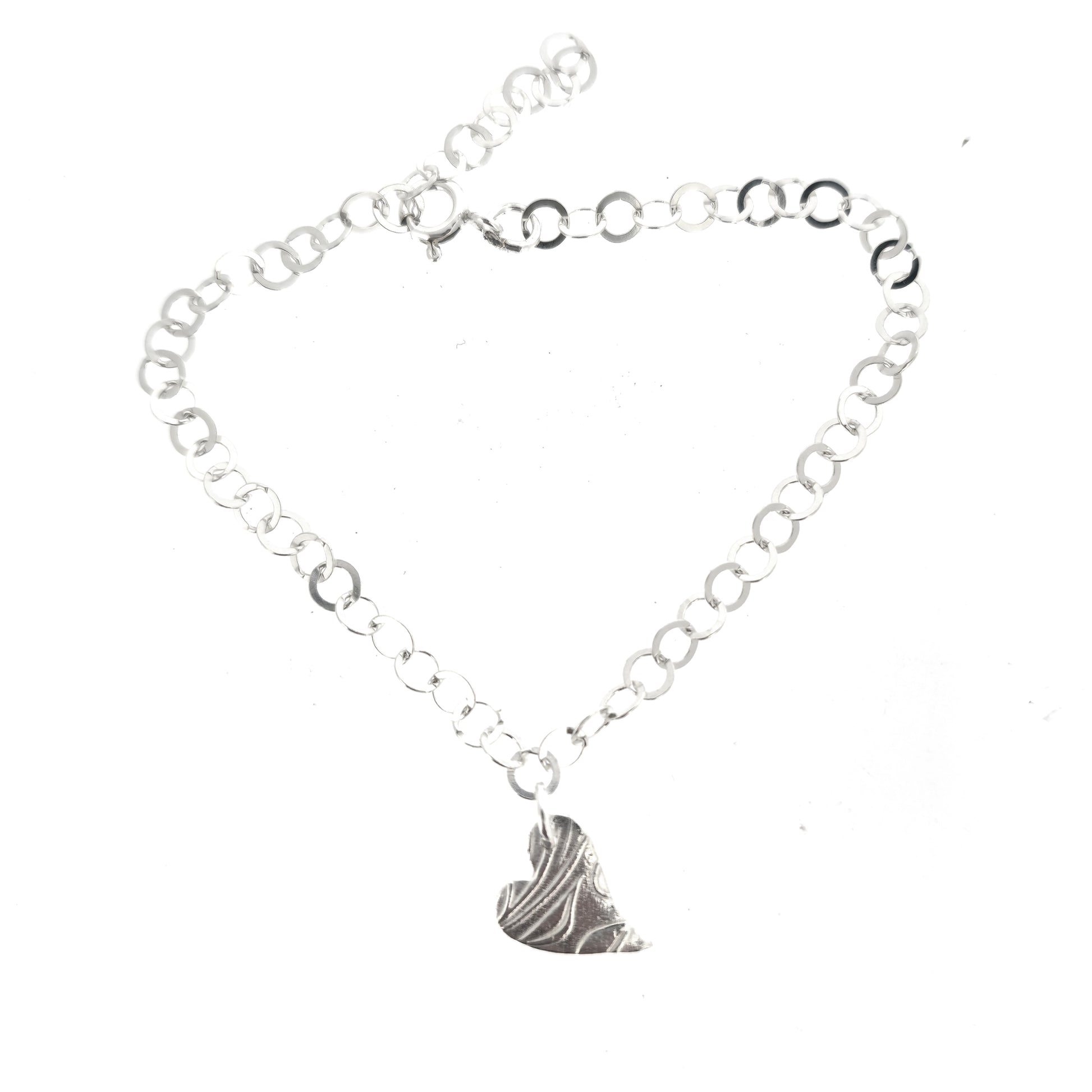 Silver large link chain bracelet with asymmetrical patterned heart charm.