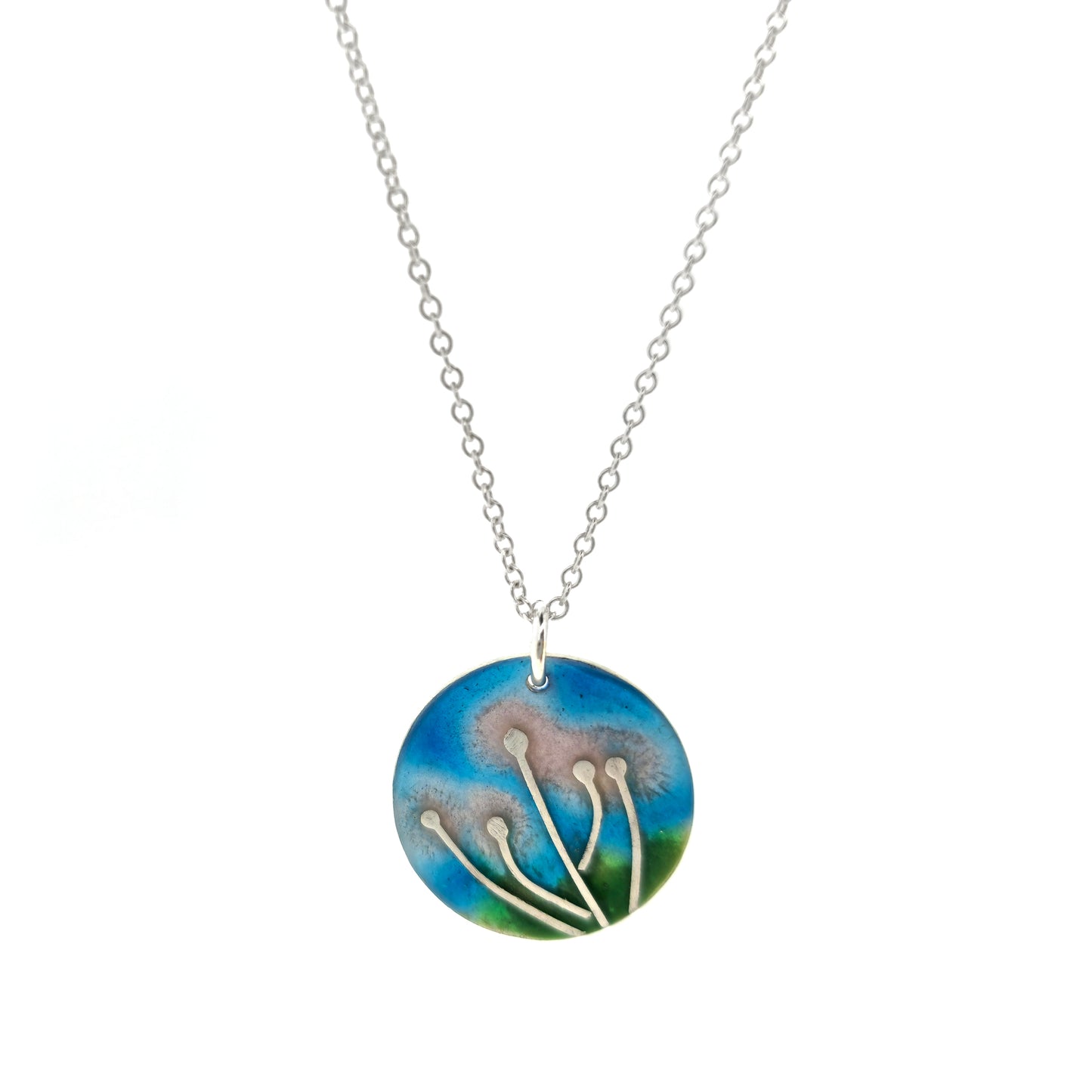 A round silver & enamel pendant with silver & pale pink flowers and a blue & green enamel background. On a silver chain.