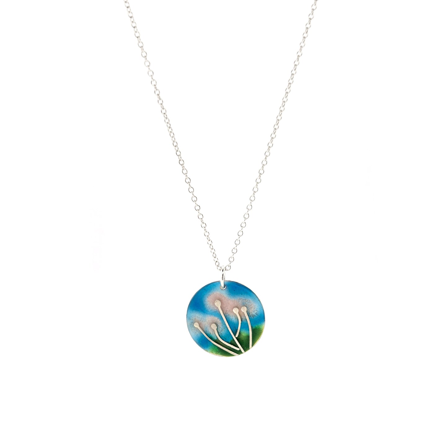 A round silver & enamel pendant with silver & pale pink flowers and a blue & green enamel background. On a silver chain.