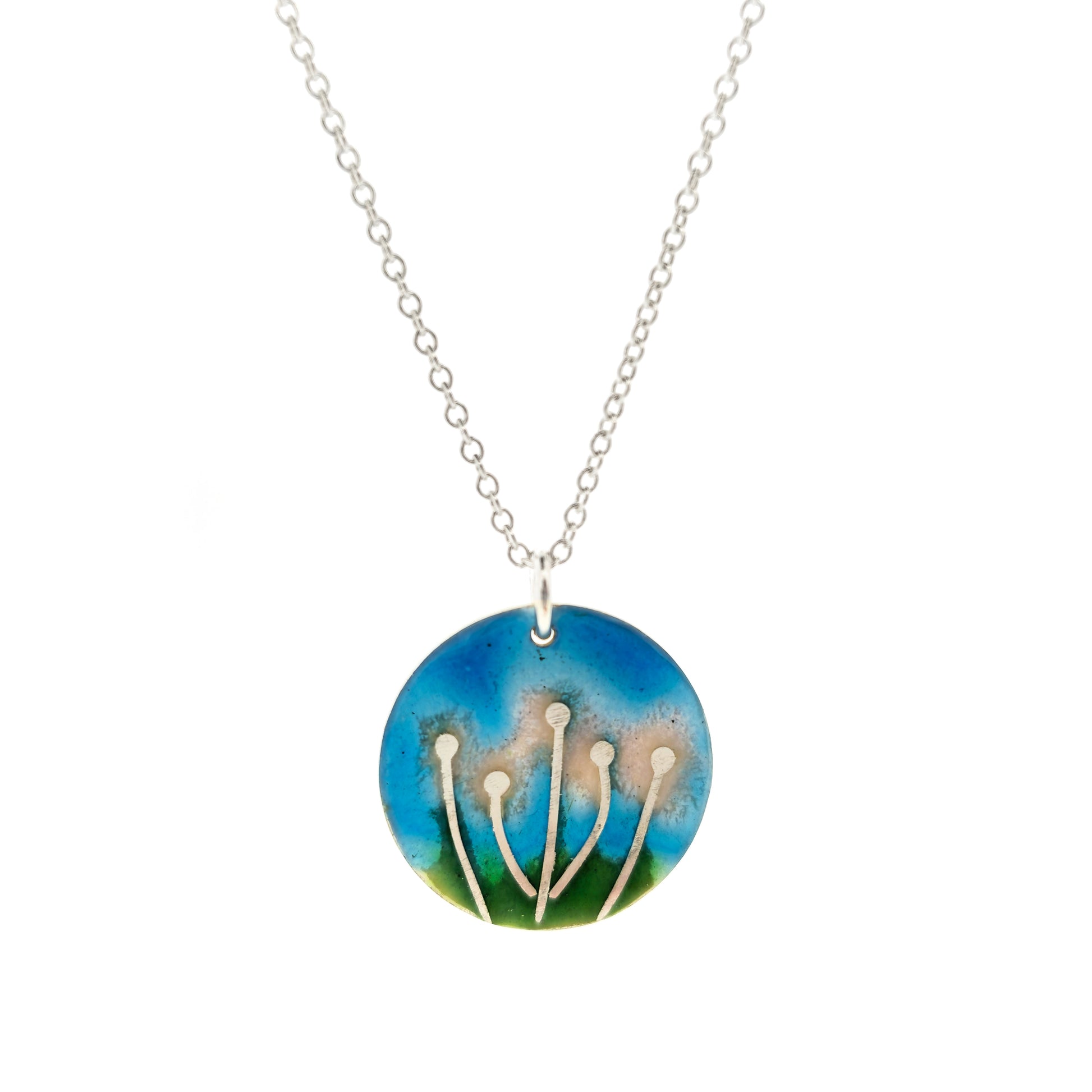 A round silver & enamel pendant with silver & pale pink flowers and a blue & green enamel background. On a silver chain.