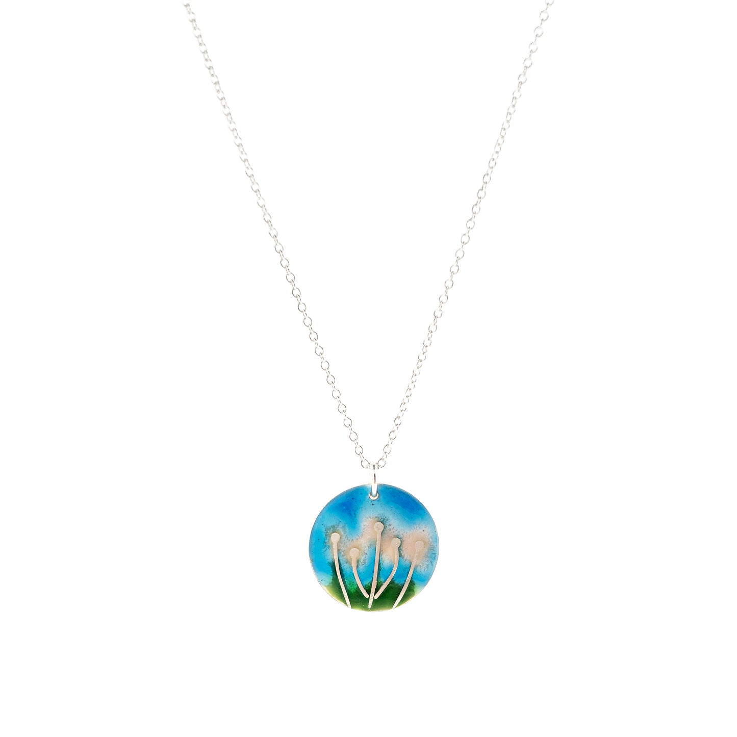 A round silver & enamel pendant with silver & pale pink flowers and a blue & green enamel background. On a silver chain.