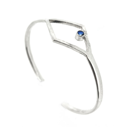 Silver open ended bangle with open diamond shape at the top featuring a round faceted blue kyanite gemstone