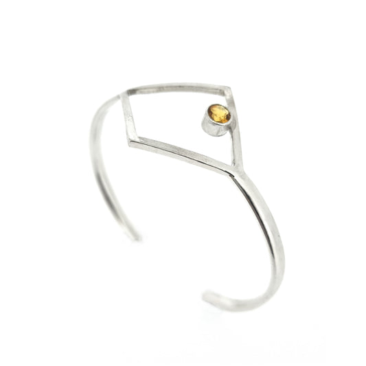 Silver torque bangle with open diamond shape and yellow citrine gemstone set inside.