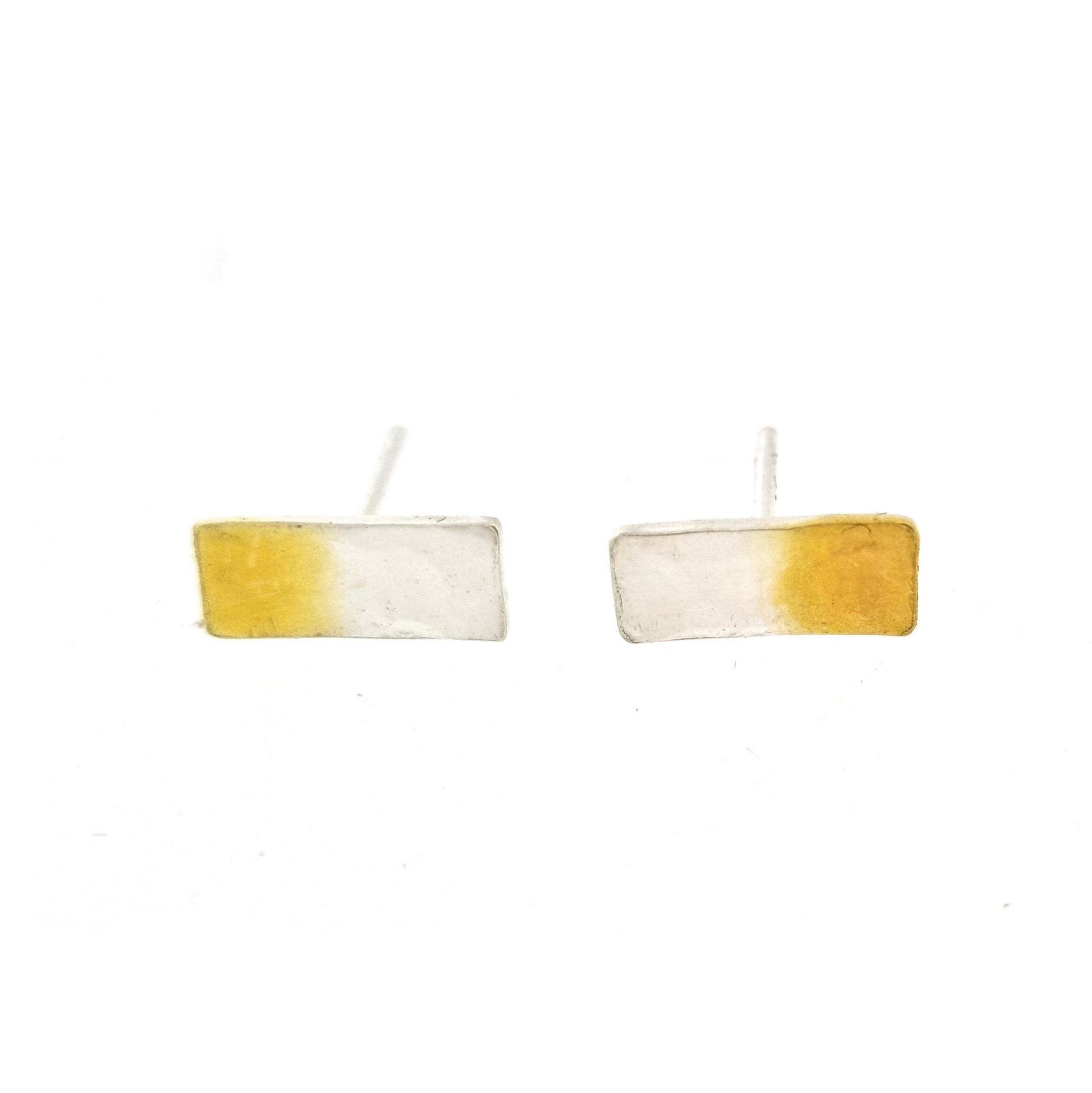 Silver rectangular stud earrings with a hammered finish and one half gold plated.