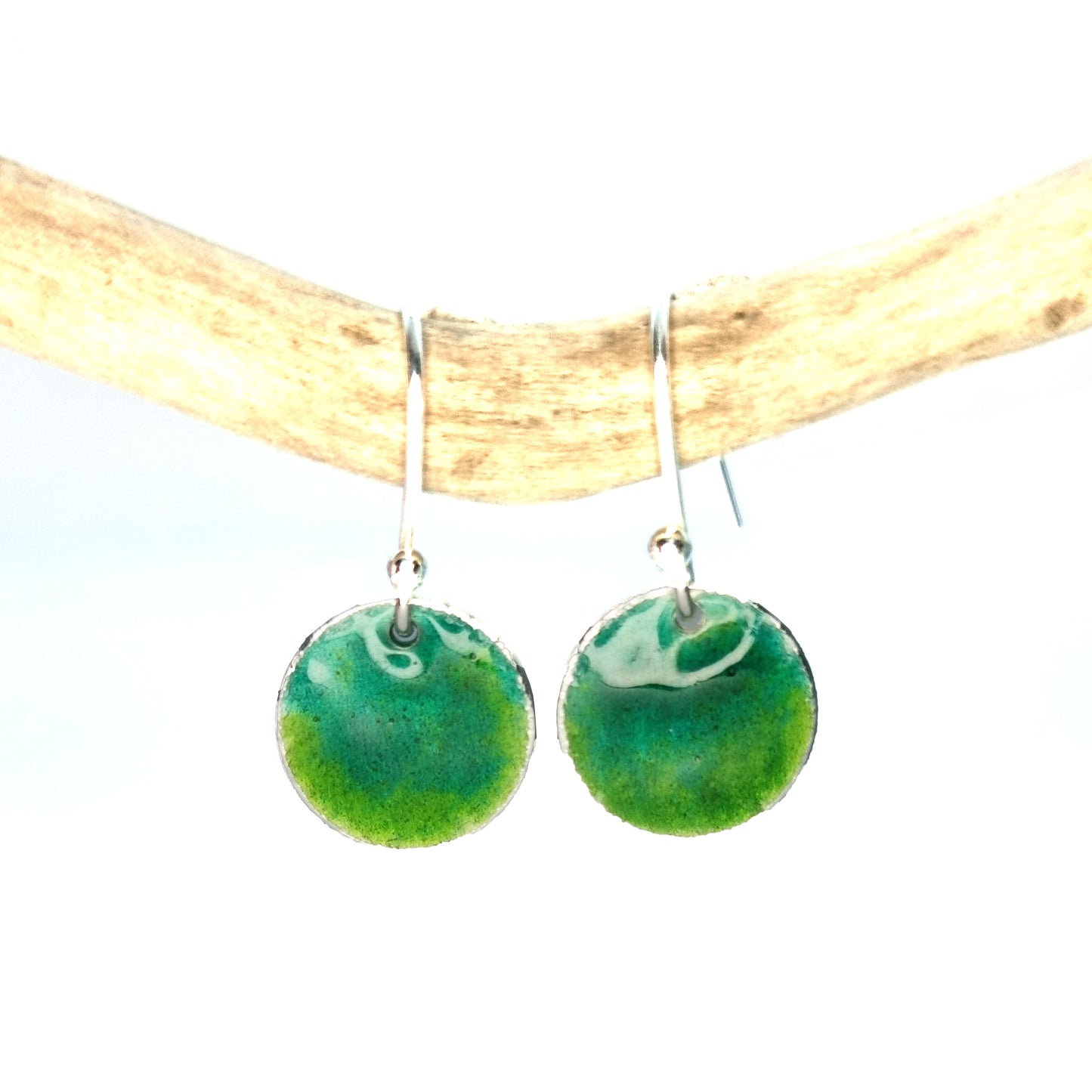 Round silver drop earrings with a mix of green enamels.