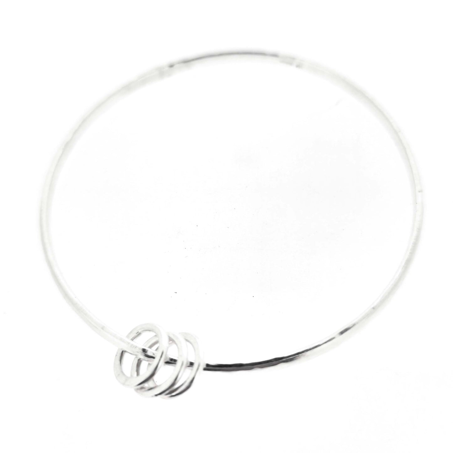 Silver textured bangle with 3 circle beads on a white background