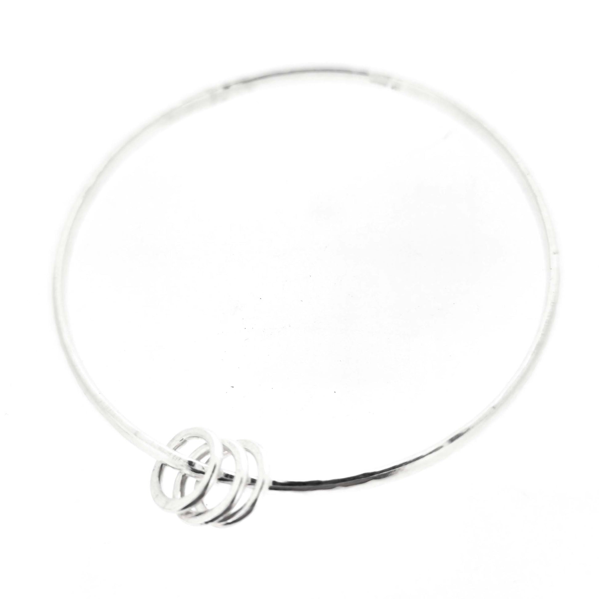 Silver textured bangle with 3 circle beads on a white background
