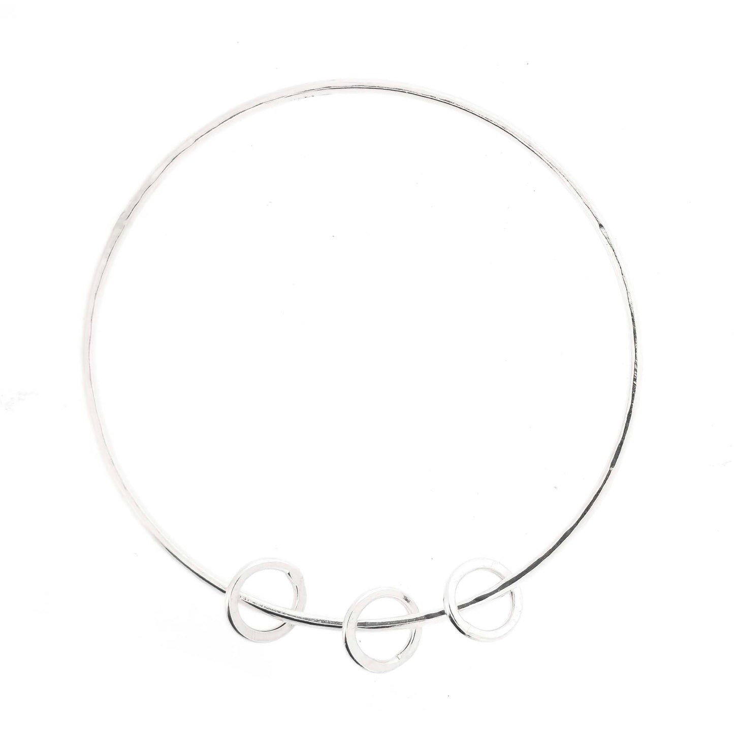 Silver textured bangle with 3 circle beads on a white background