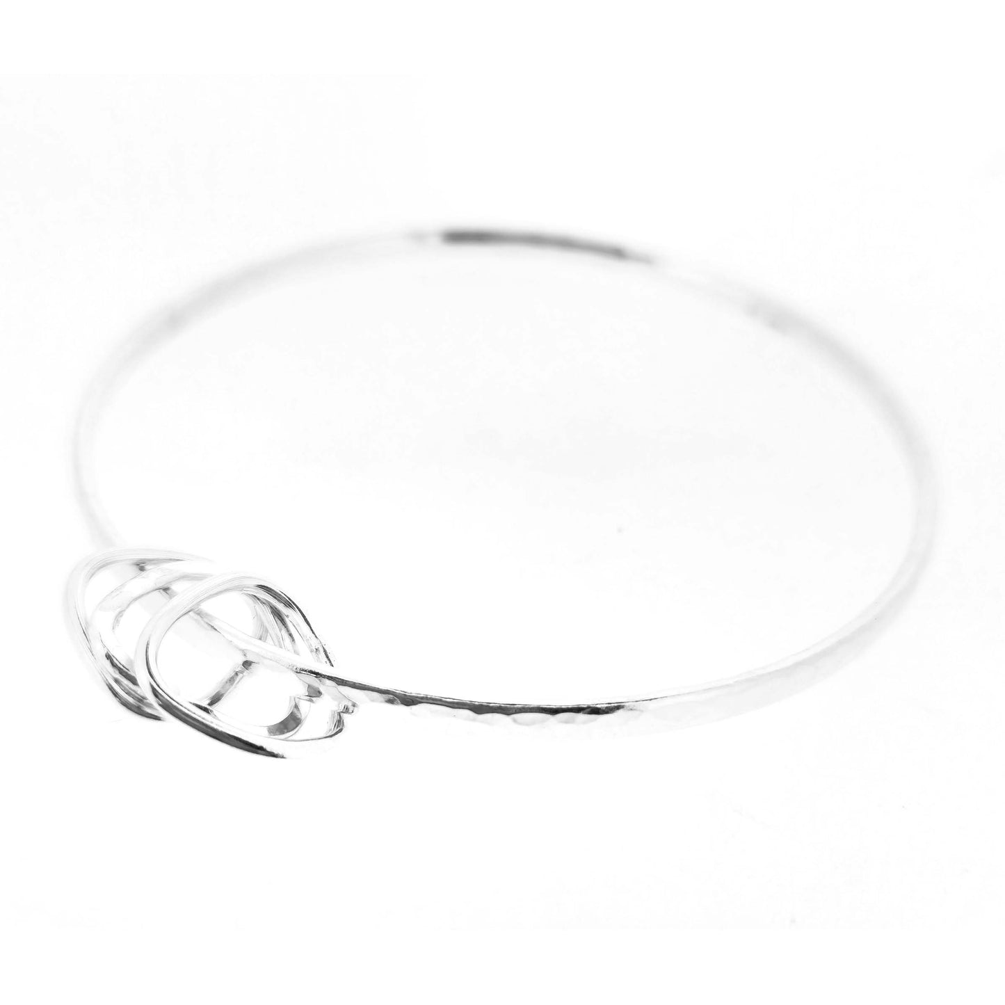 Silver hammered bangle with 3 soft edged open triangle charms on a white background.
