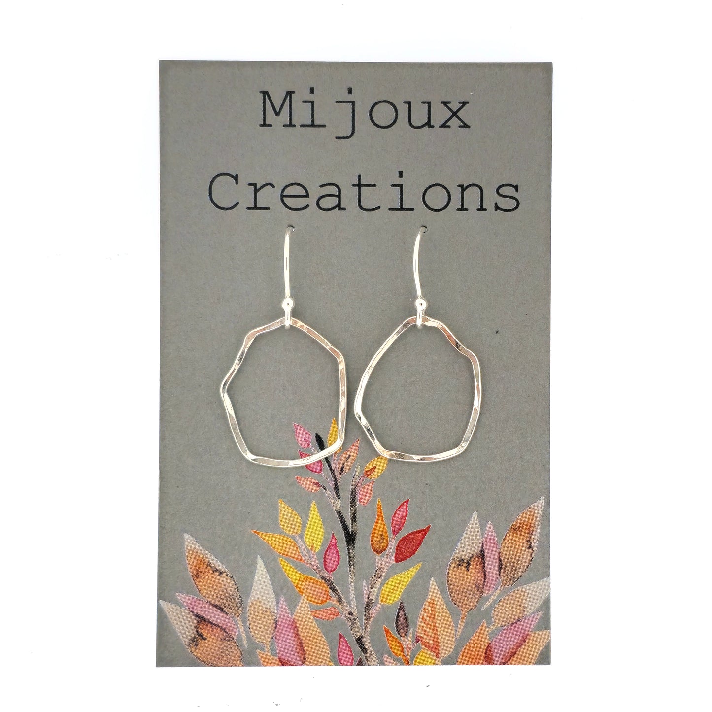 Silver drop earrings with an open organic rustic style circle suspended from silver ear wires - large. Shown on a Mijoux card. 