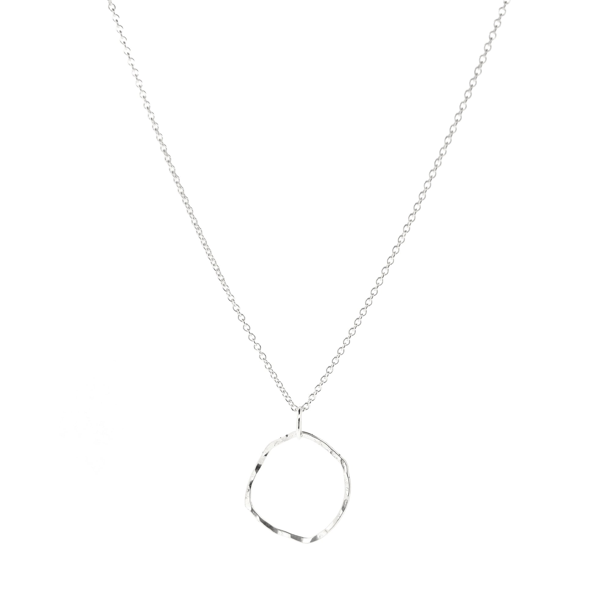 A silver pendant necklace consisting of an open organic rustic style silver circle with a hammered finish suspended from a silver chain - large.