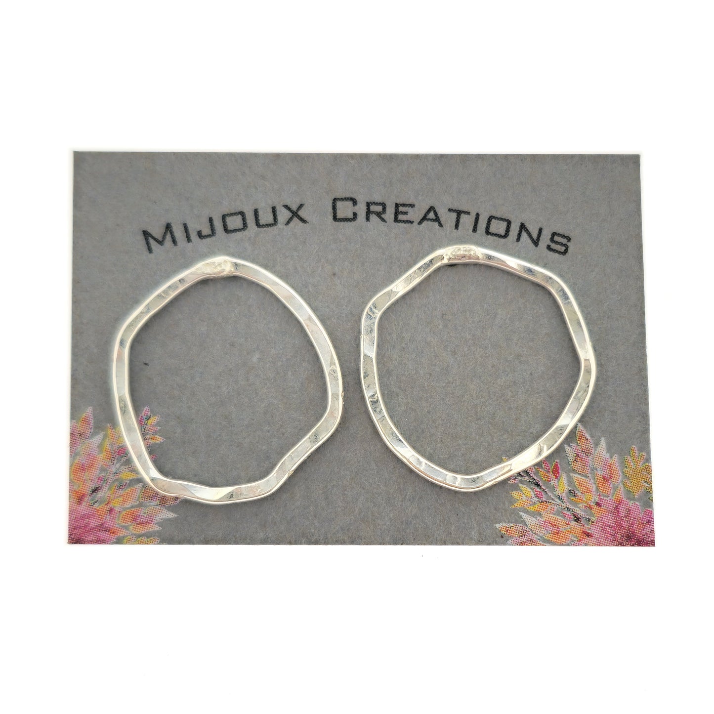 Silver open stud earrings of an organic rustic circle shape - large. Shown on a Mijoux card.