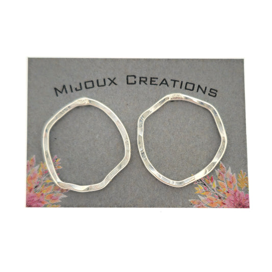 Silver open stud earrings of an organic rustic circle shape - large. Shown on a Mijoux card.