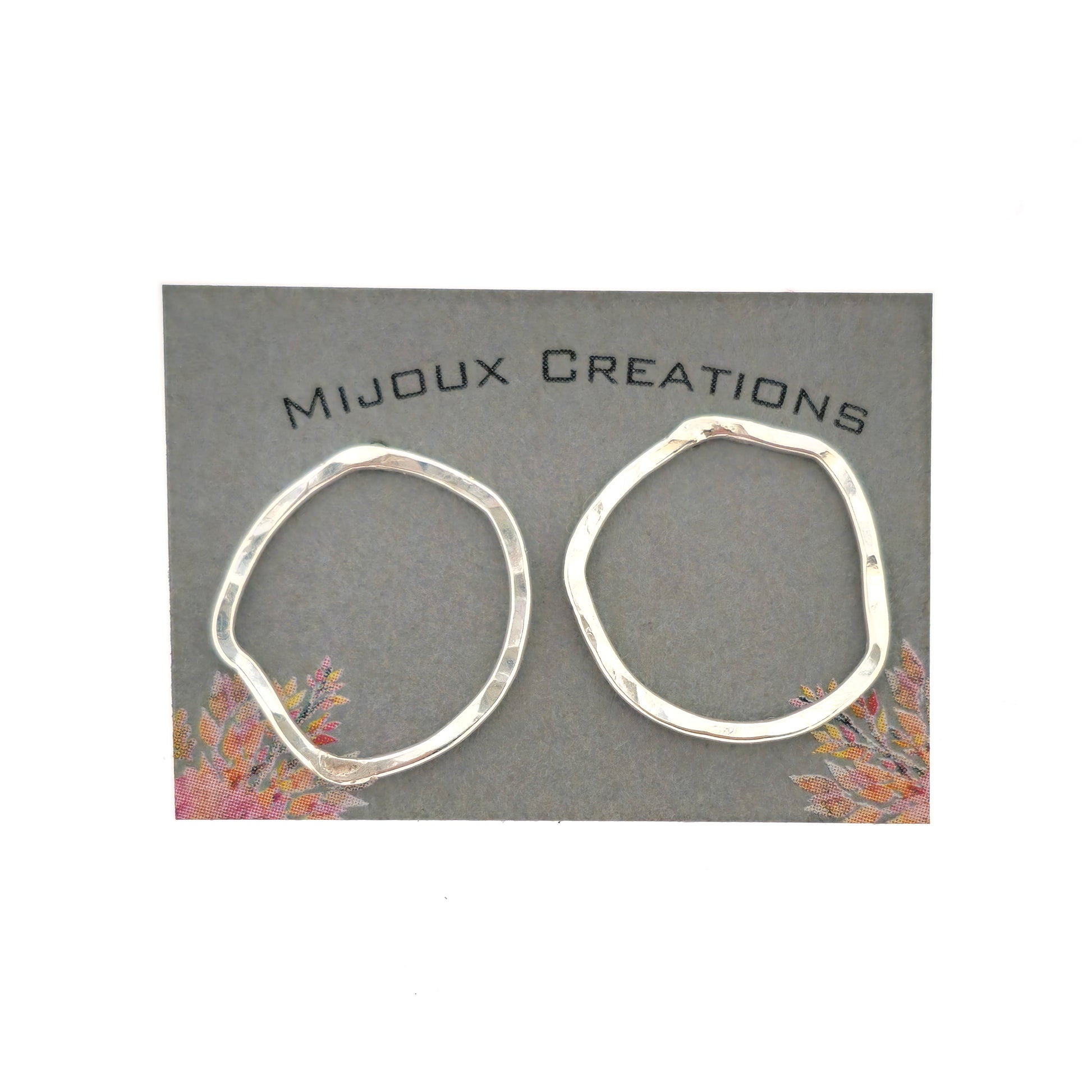 Silver open stud earrings of an organic rustic circle shape - large. Shown on a Mijoux card.