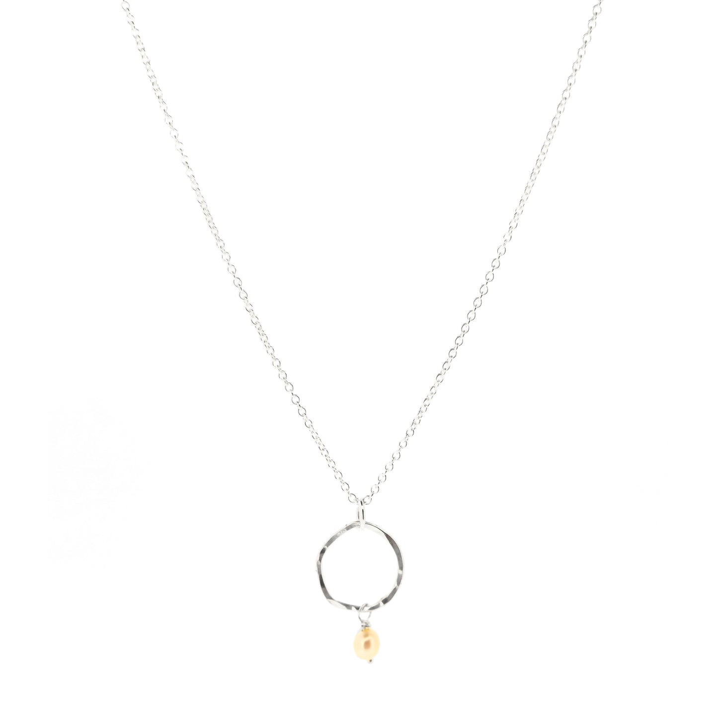 A silver pendant consisting of an organic rustic style open circle with a hammered finish and a pearl suspended from it. Hanging from a silver chain. Small.