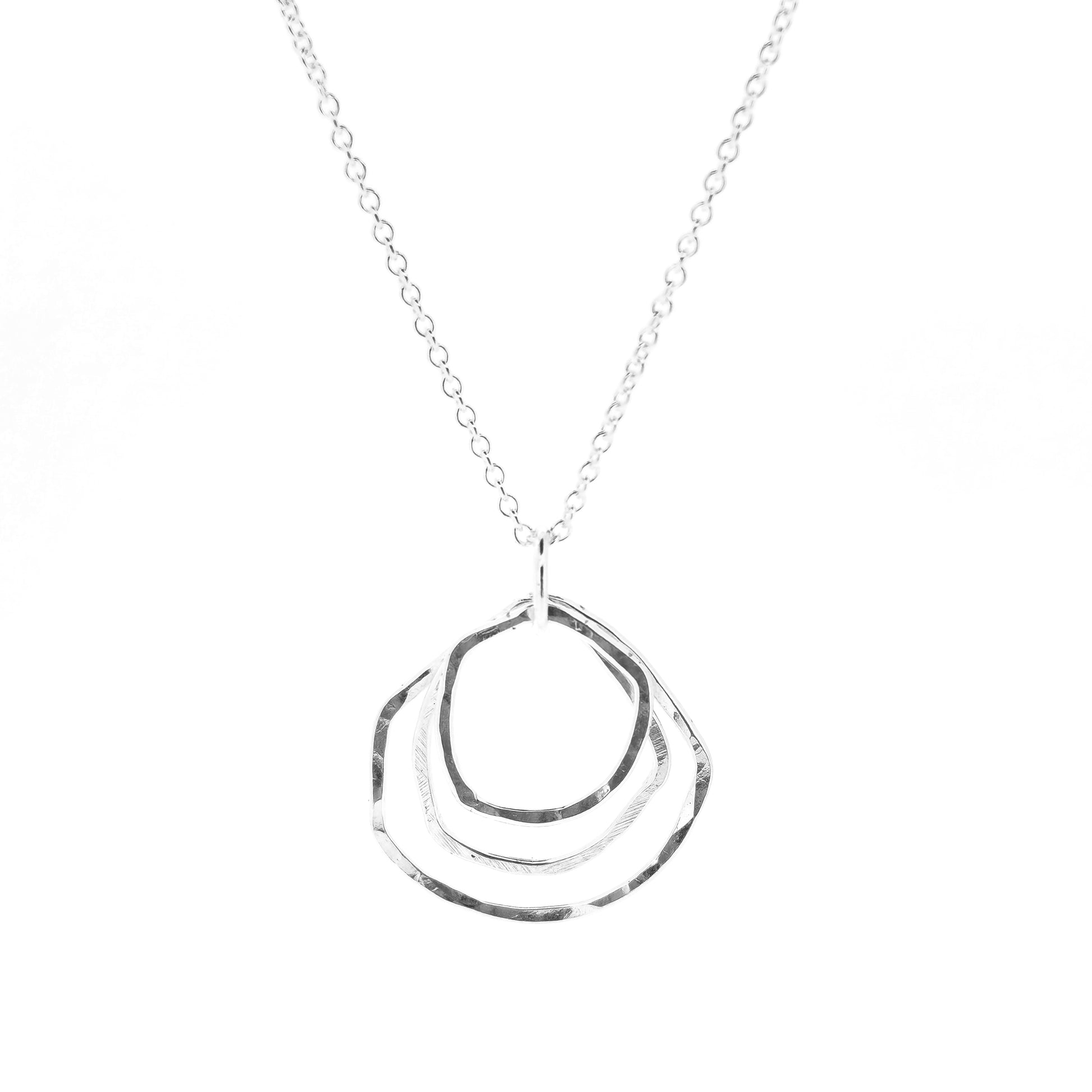 A silver pendant consisting of three organic rustic style circles of different sizes suspended together from a silver chain.