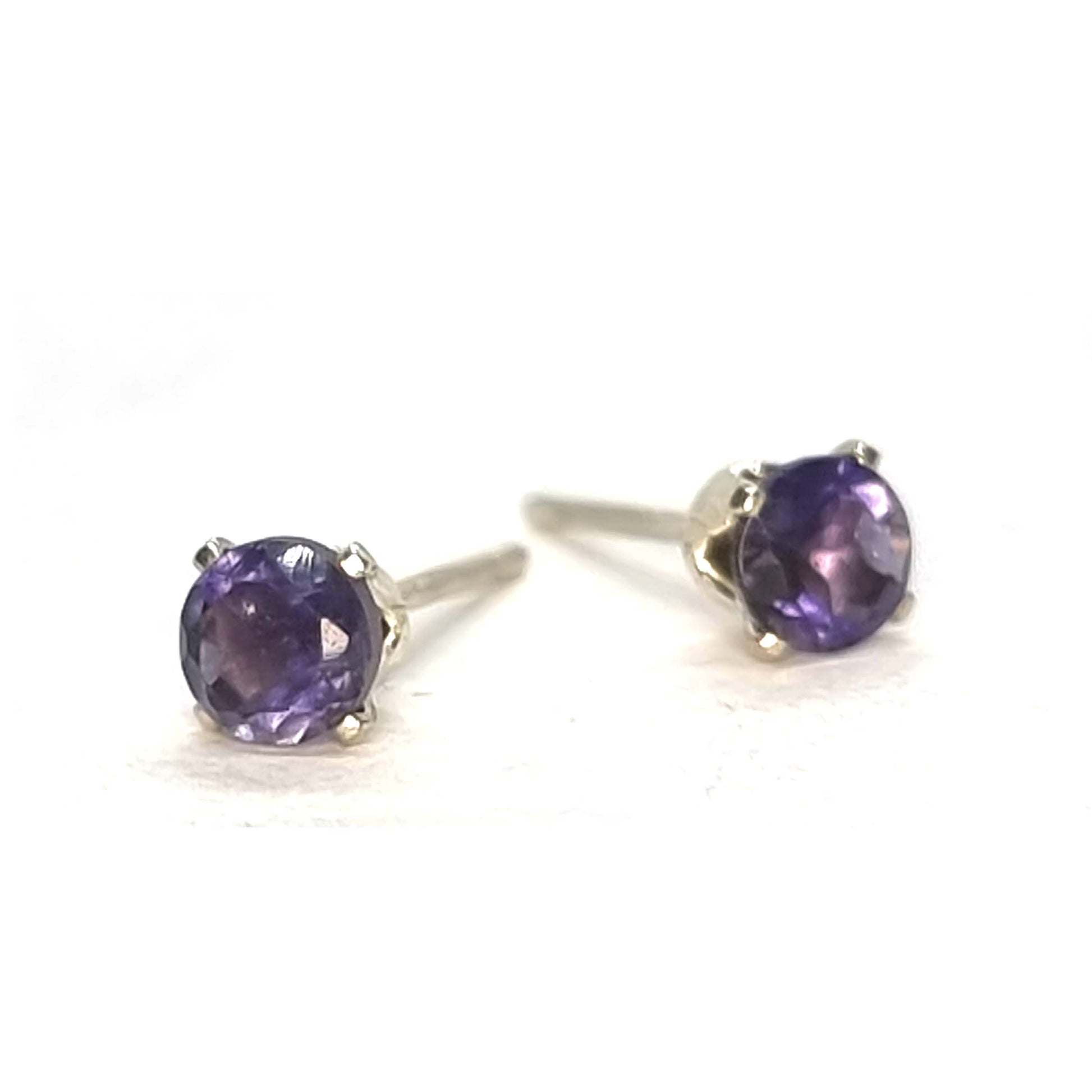 Pair of purple gemstone stud earrings on a white background