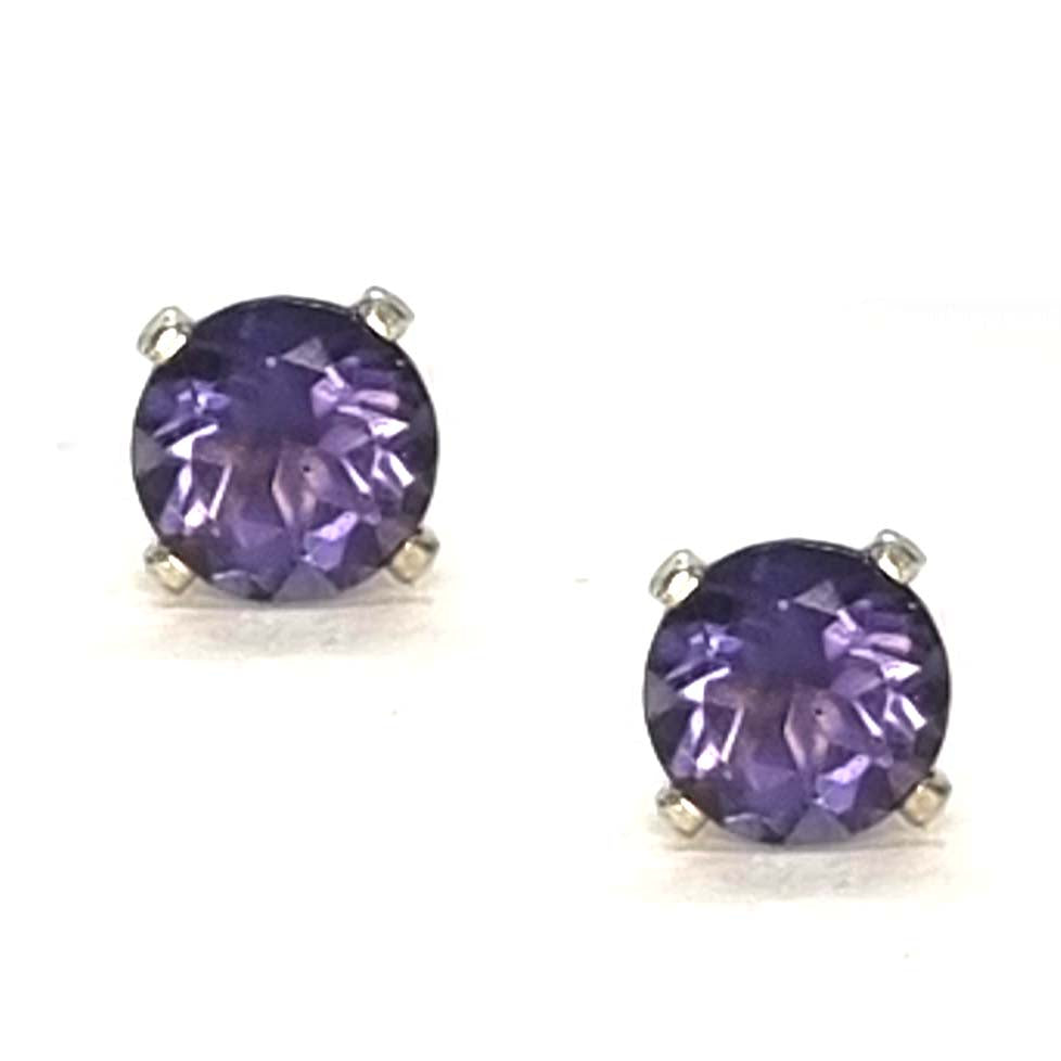 Pair of purple gemstone stud earrings with a 4 claw setting on a white background