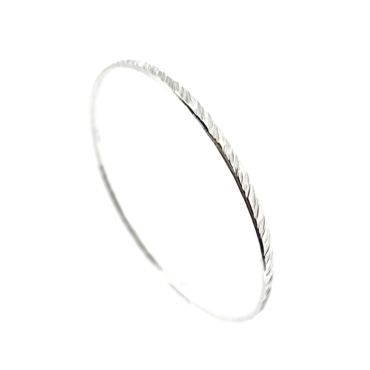 A silver round bangle with a diagonal rustic lined texture.