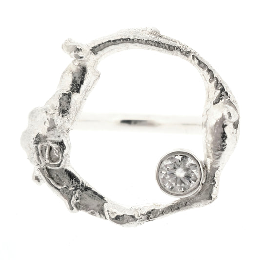 A sterling silver ring with a large molten open circle top and a white moissanite gemstone. Mijoux jewellery. Top view.