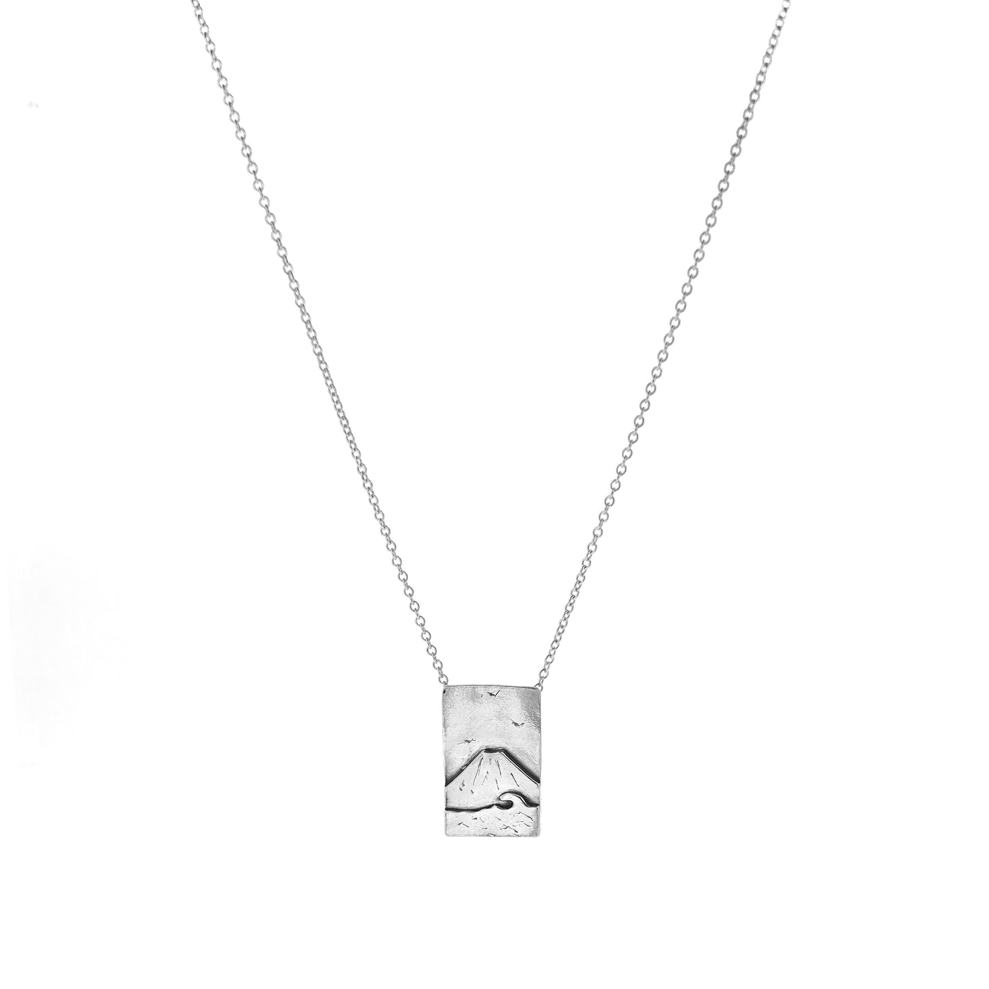 A rectangular silver pendant with a mountain scene featuring Mount Fuji behind a sea with a wave and birds in the sky. On a silver chain with invisible bail. Mijoux Creations.