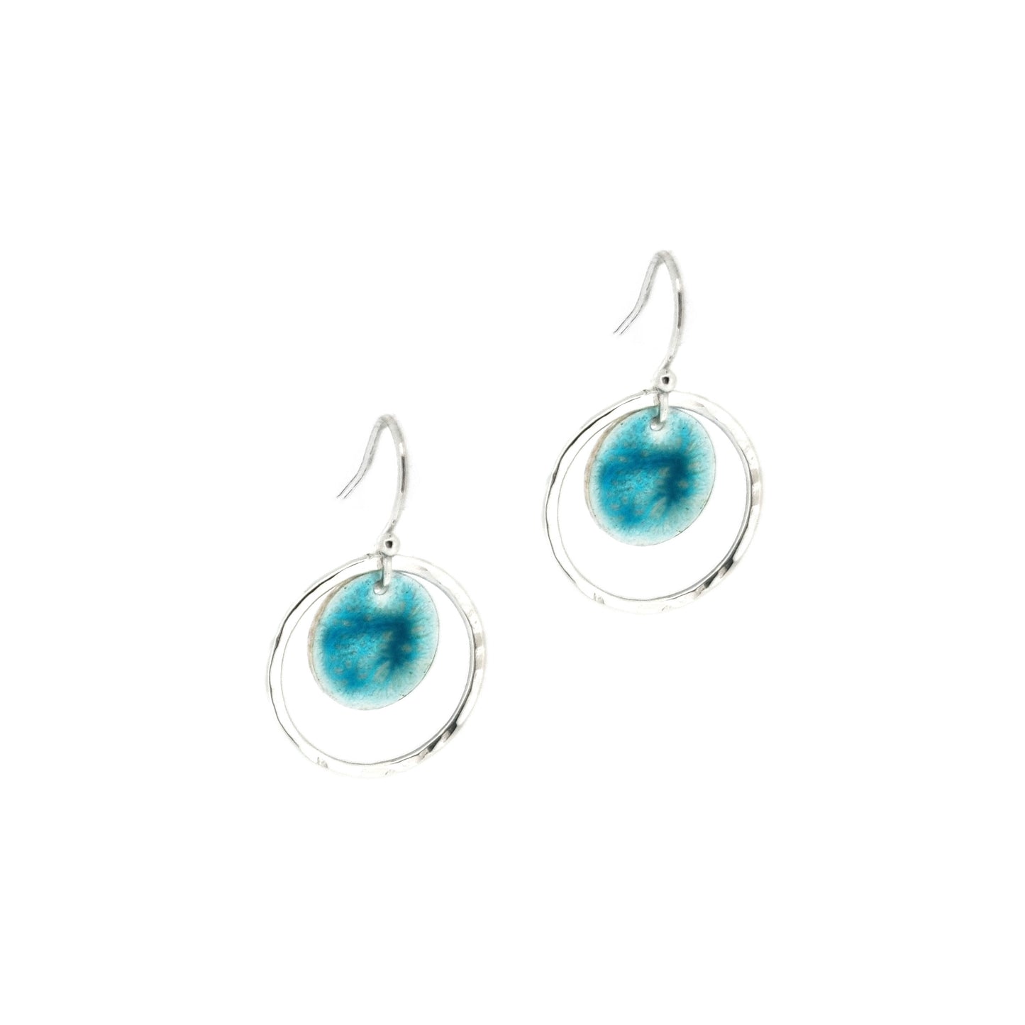 Silver drop earrings with a central silver disc covered with a turquoise enamel pattern and a surrounding hammered silver circle.