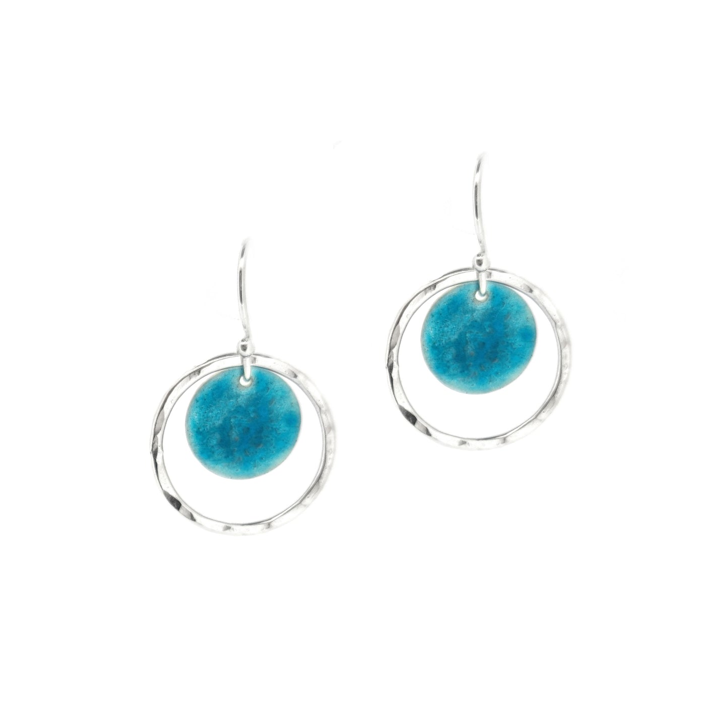 Silver drop earrings with a central silver disc covered with a turquoise enamel pattern and a surrounding hammered silver circle.