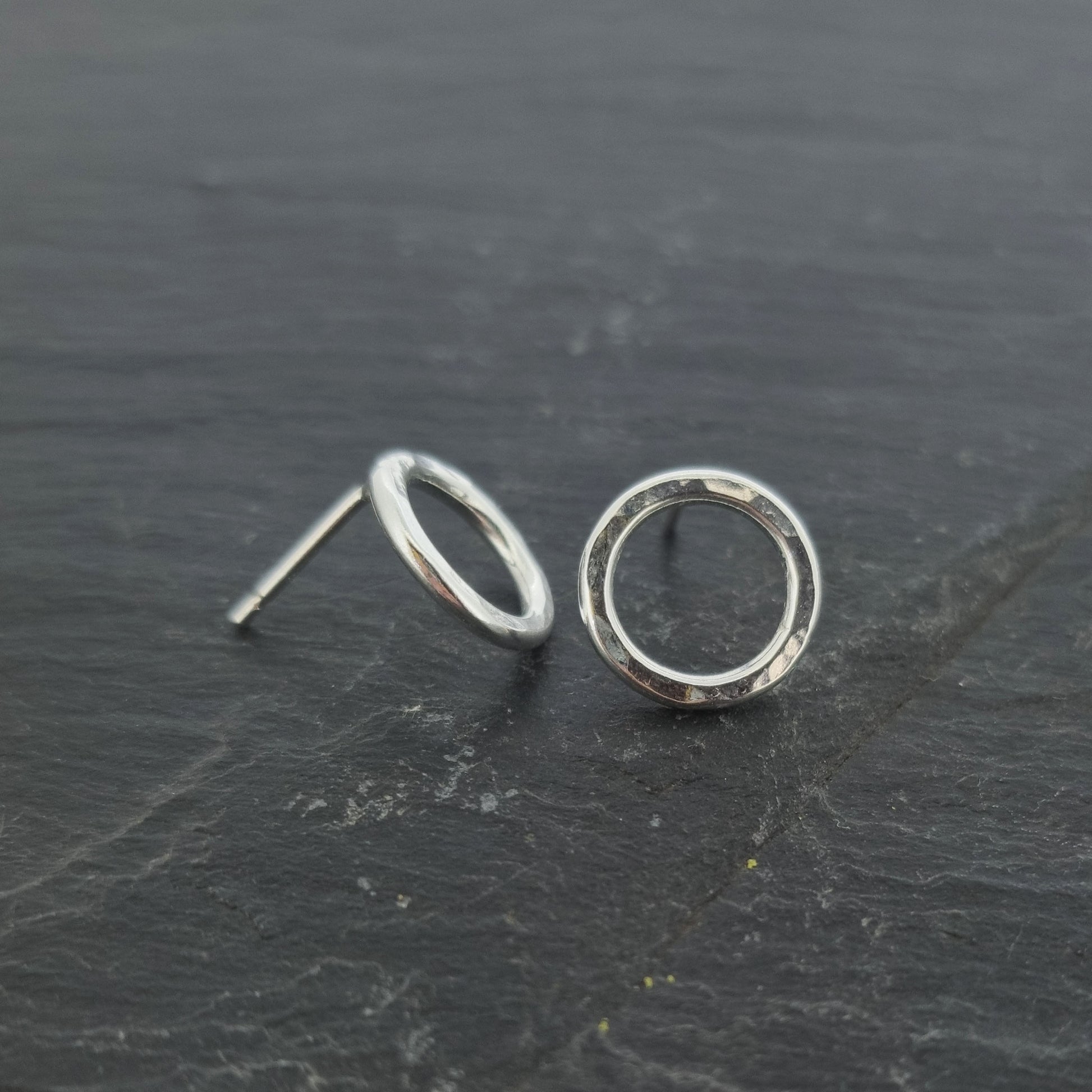Silver open circle stud earrings with hammered texture.