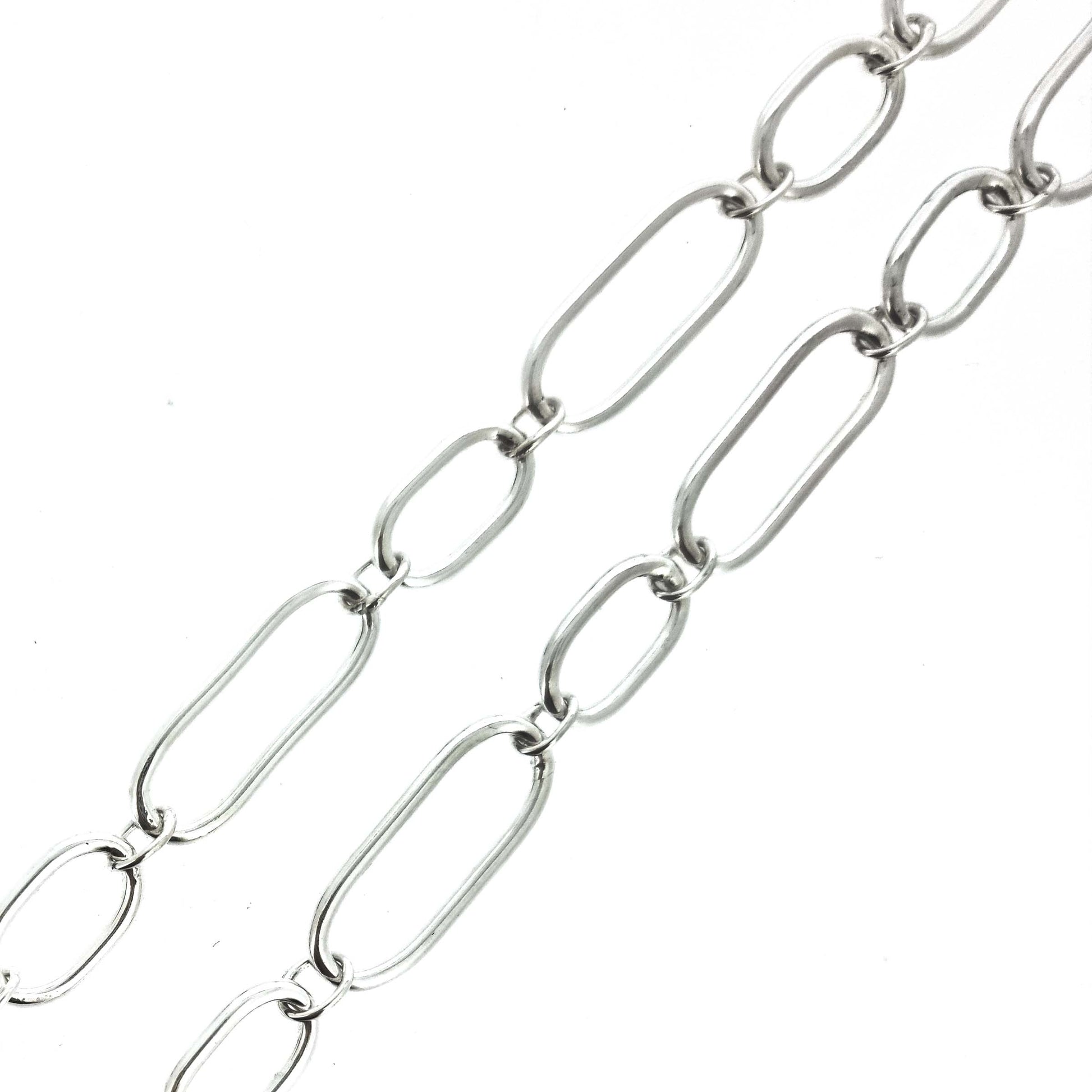 Silver chain bracelet with oblong links of different sizes.
