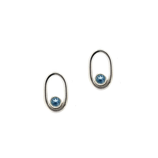 Silver open oblong stud earrings with a blue topaz gemstone set inside one curve.