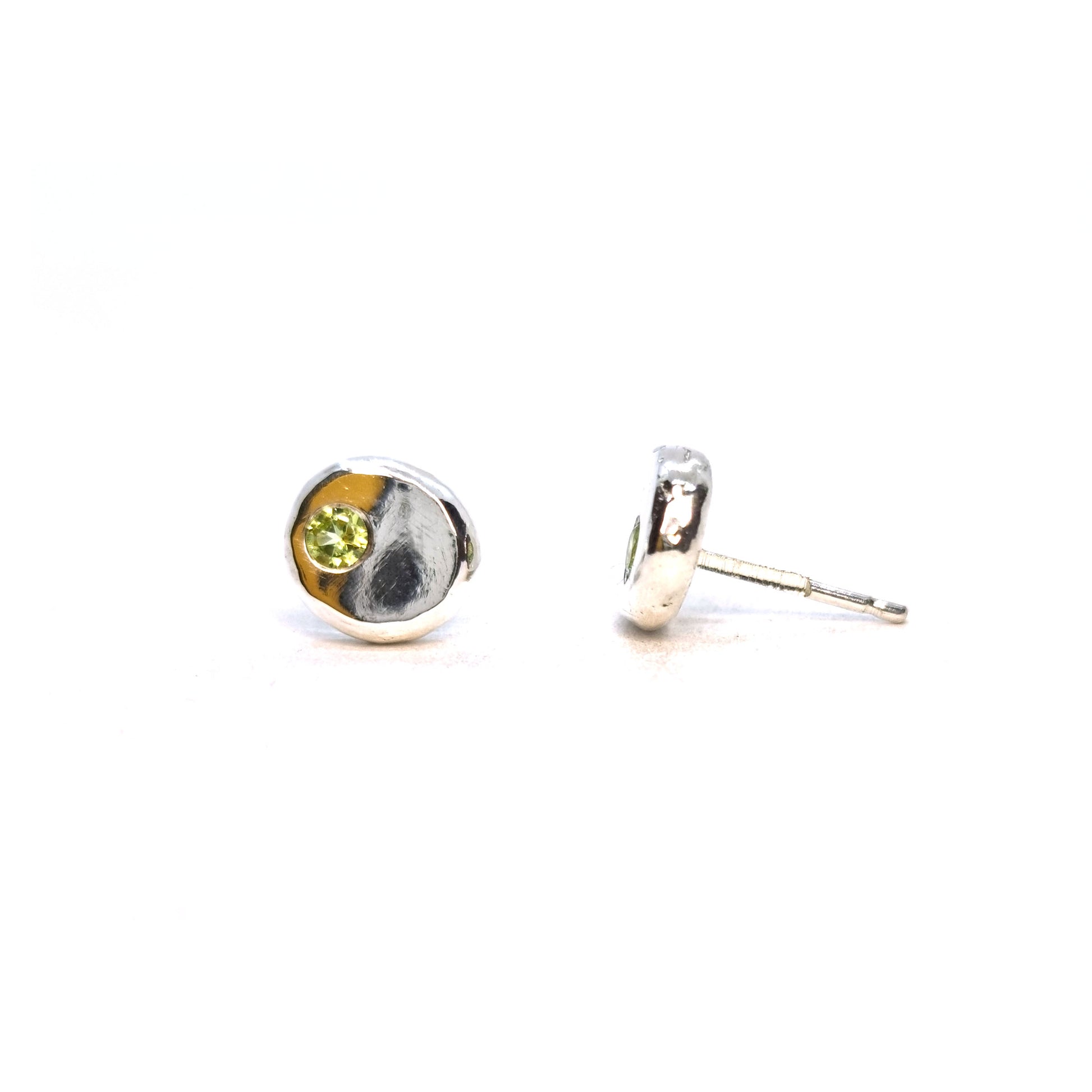 Silver round flat 'pebble' stud earrings set with pale green peridot gemstones.