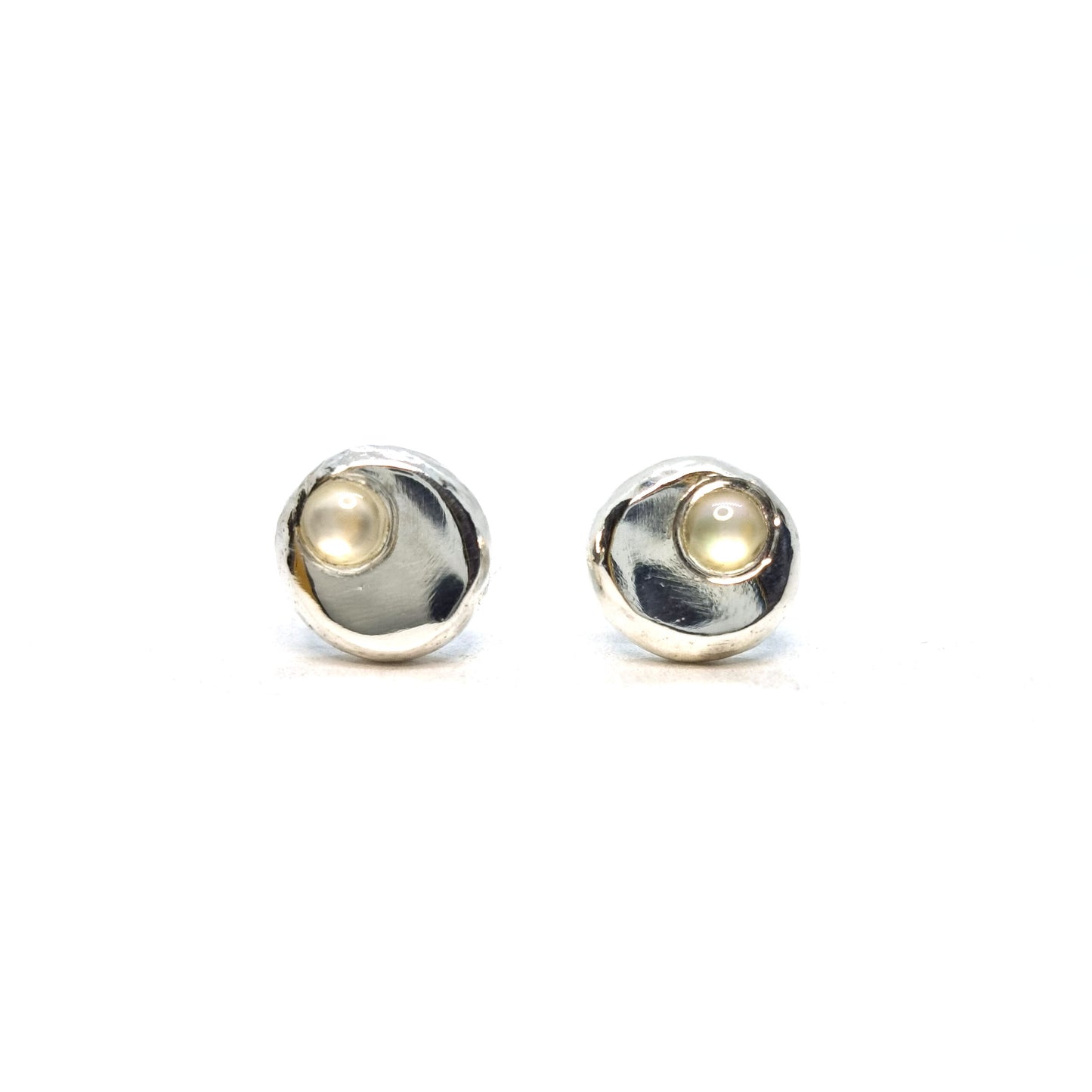 Round silver pebble stud earrings with mother of pearl gemstones flush set off-centre.