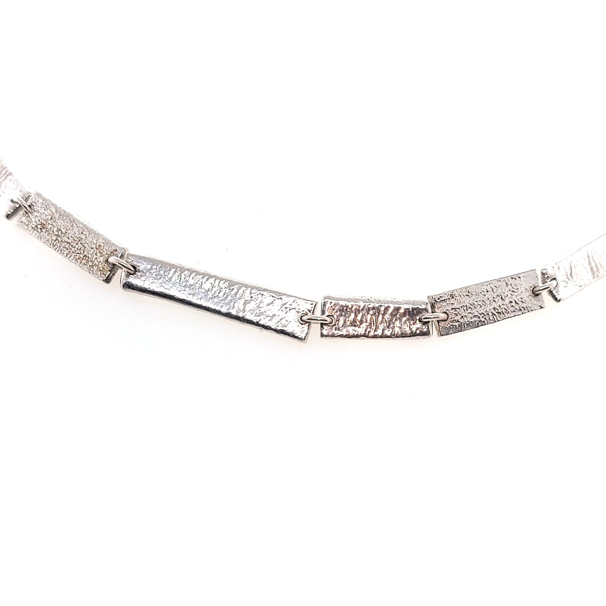 Silver necklace with textured rectangular links of different sizes.