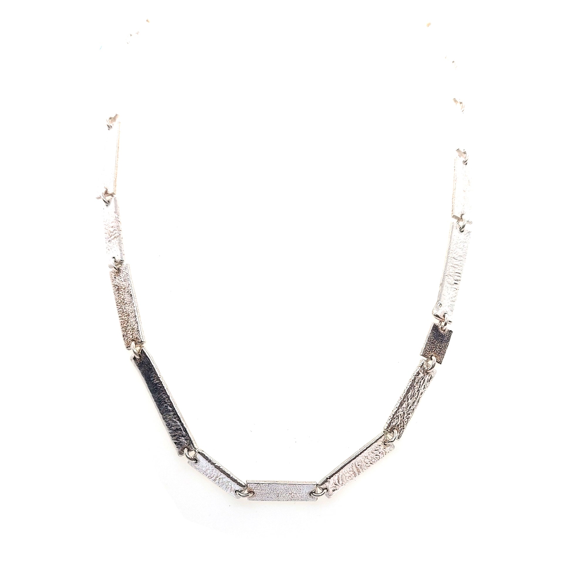 Silver necklace with textured rectangular links of different sizes.