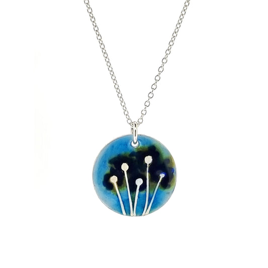 A round silver pendant with silver flowers and blue enamel. On a silver chain.