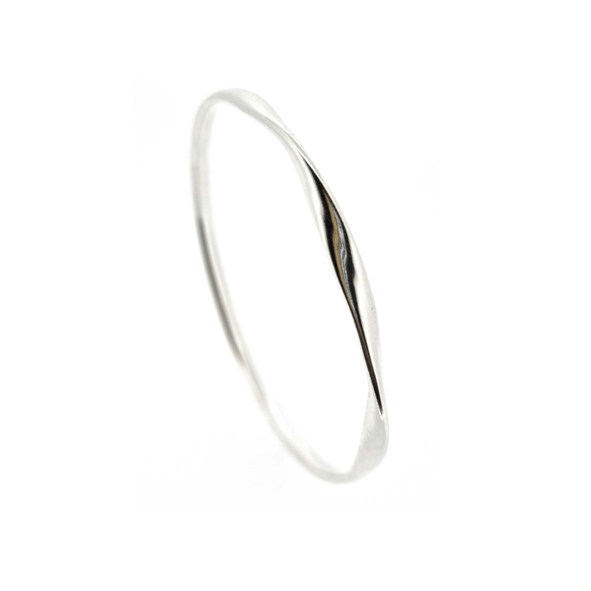 Round silver bangle with oval profile and a twist in one part.