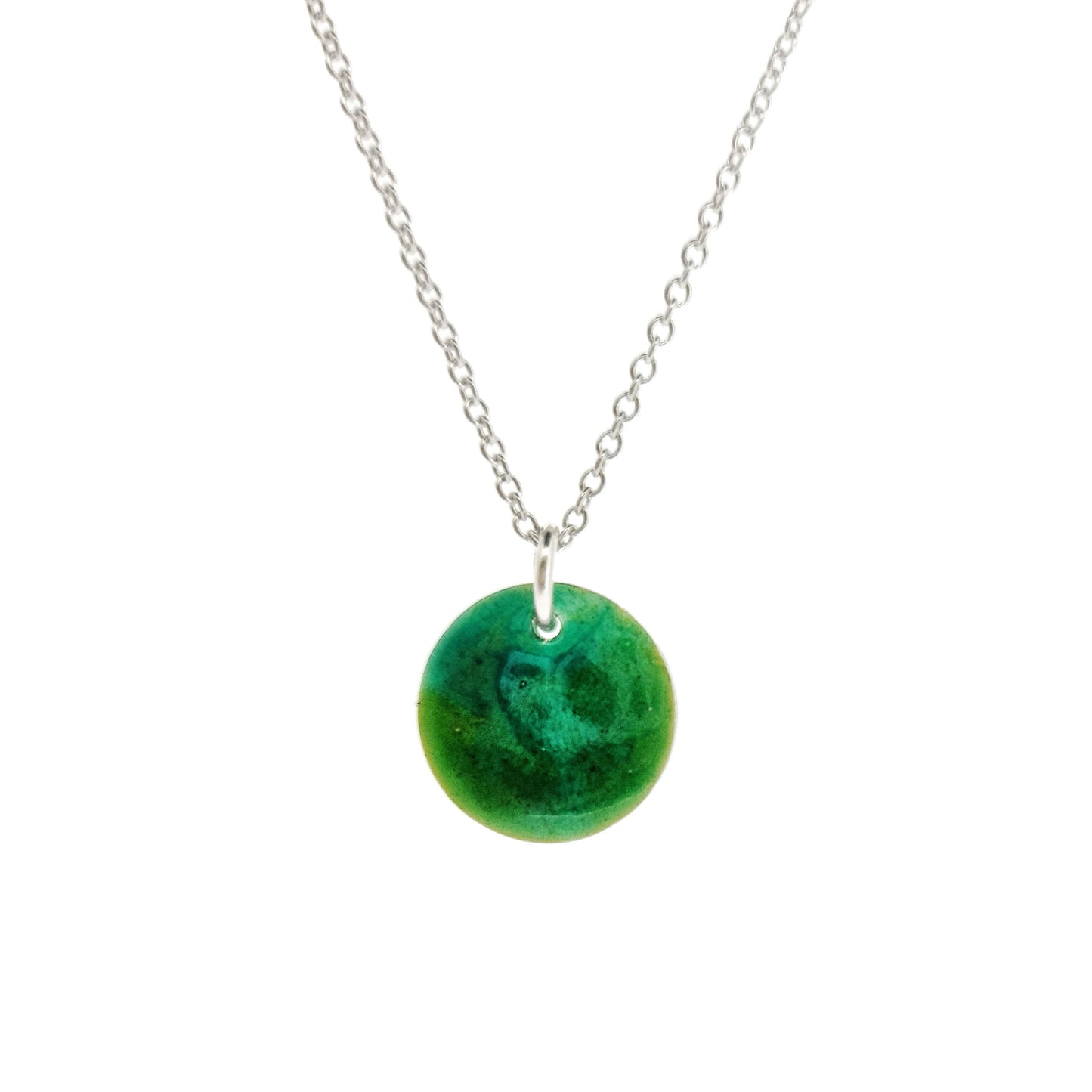 A round silver pendant with a mix of green enamels. On a silver chain.