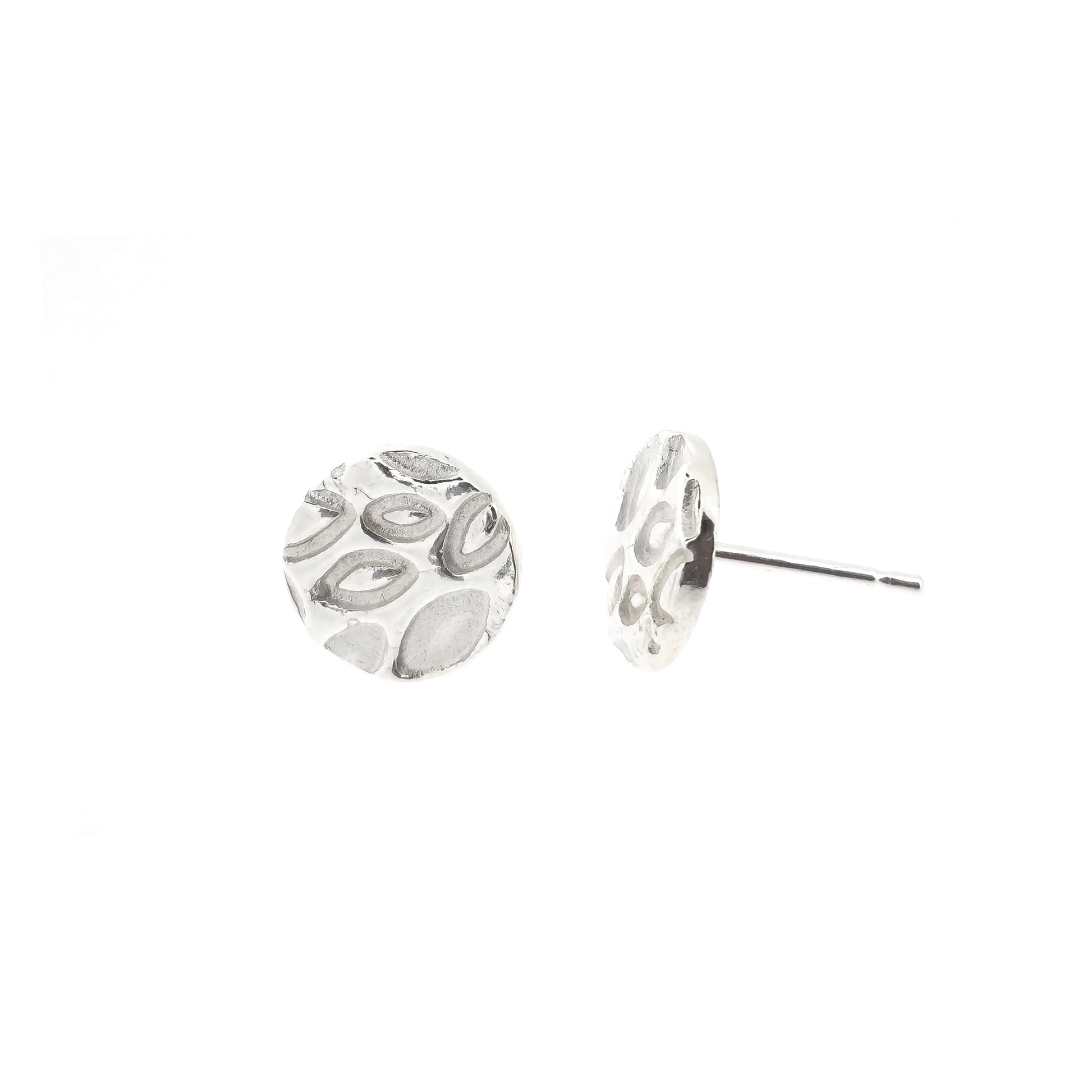 A pair of round silver stud earrings with a marquise (or leaf) shaped pattern on. One shown at the front, one shown to the side.