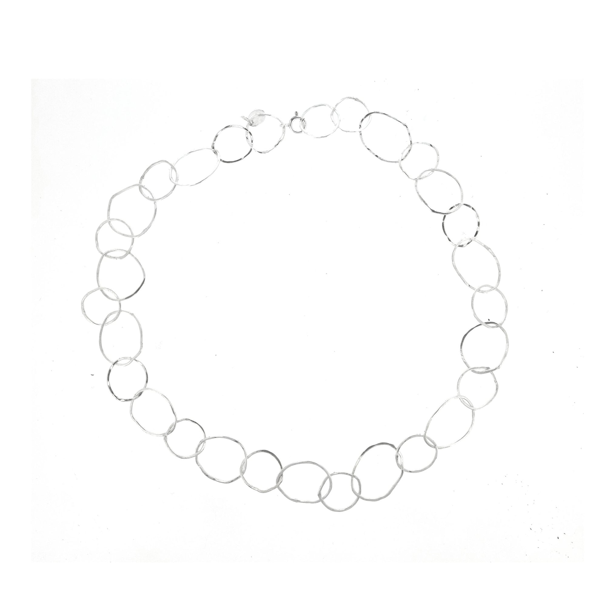 A silver necklace made of organic style circular links of various sizes.