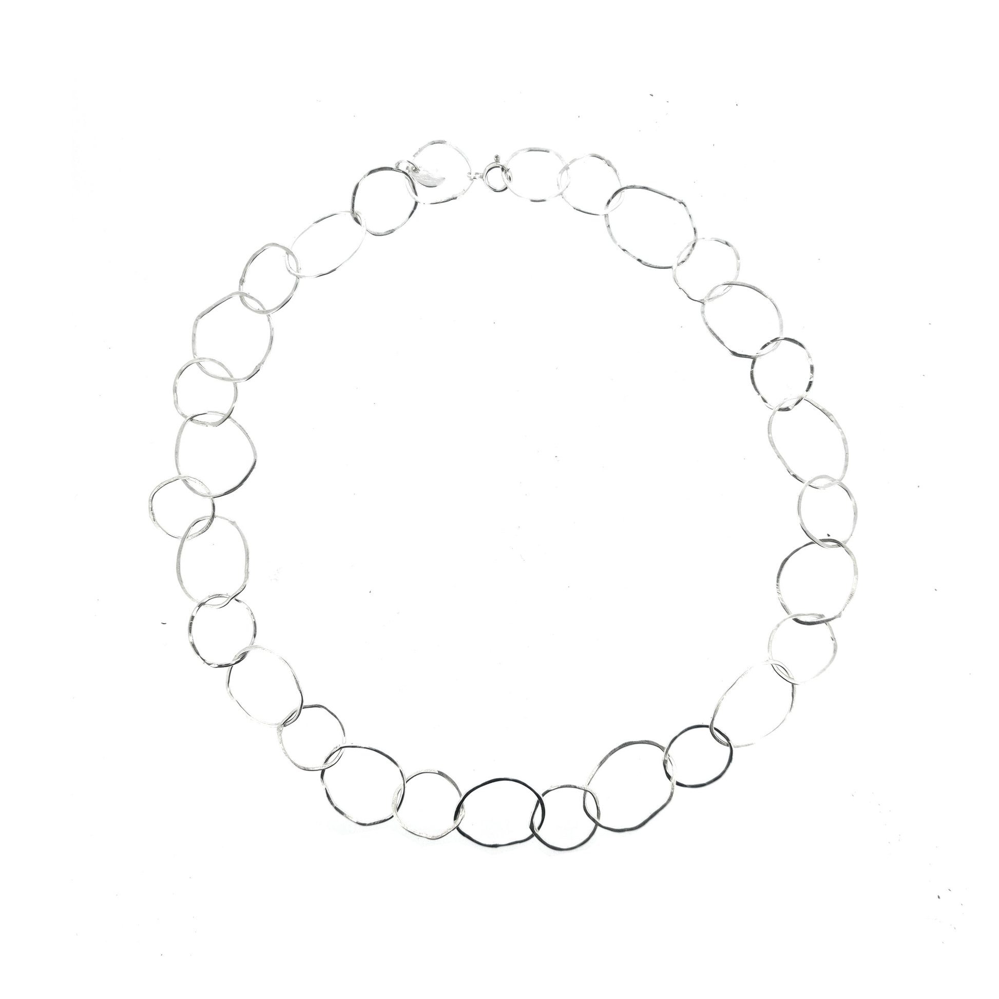 A silver necklace made of organic style circular links of various sizes.